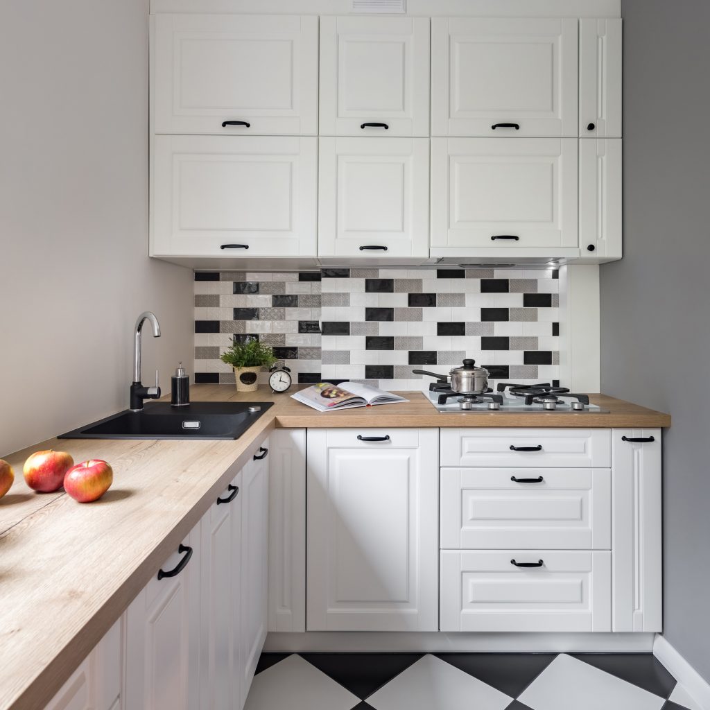 Small kitchen with classic white furniture and modern floor tiles