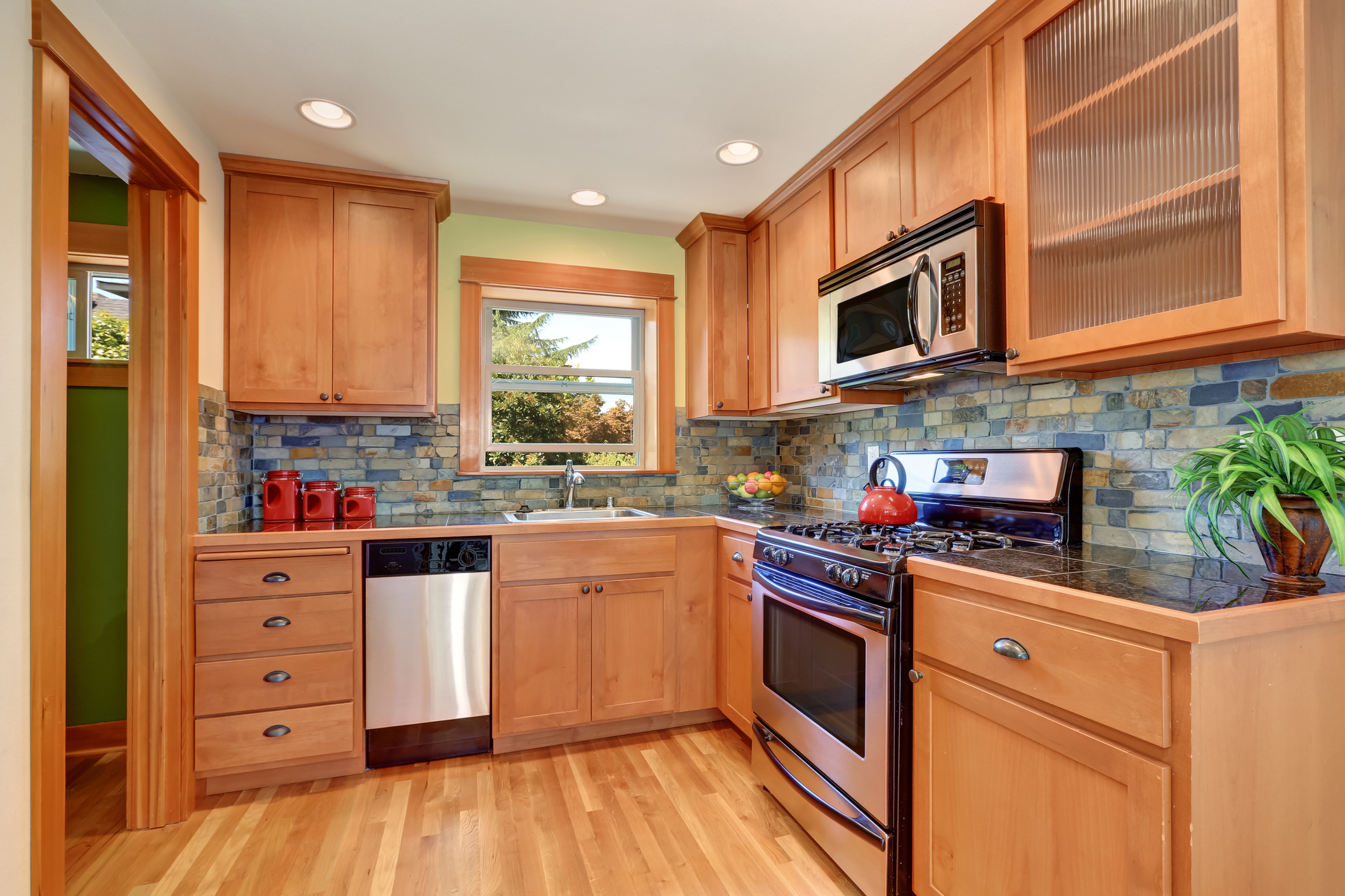 Light brown kitchen cabinetry and brick tile back splash trim. Kitchen interior. Northwest, USA