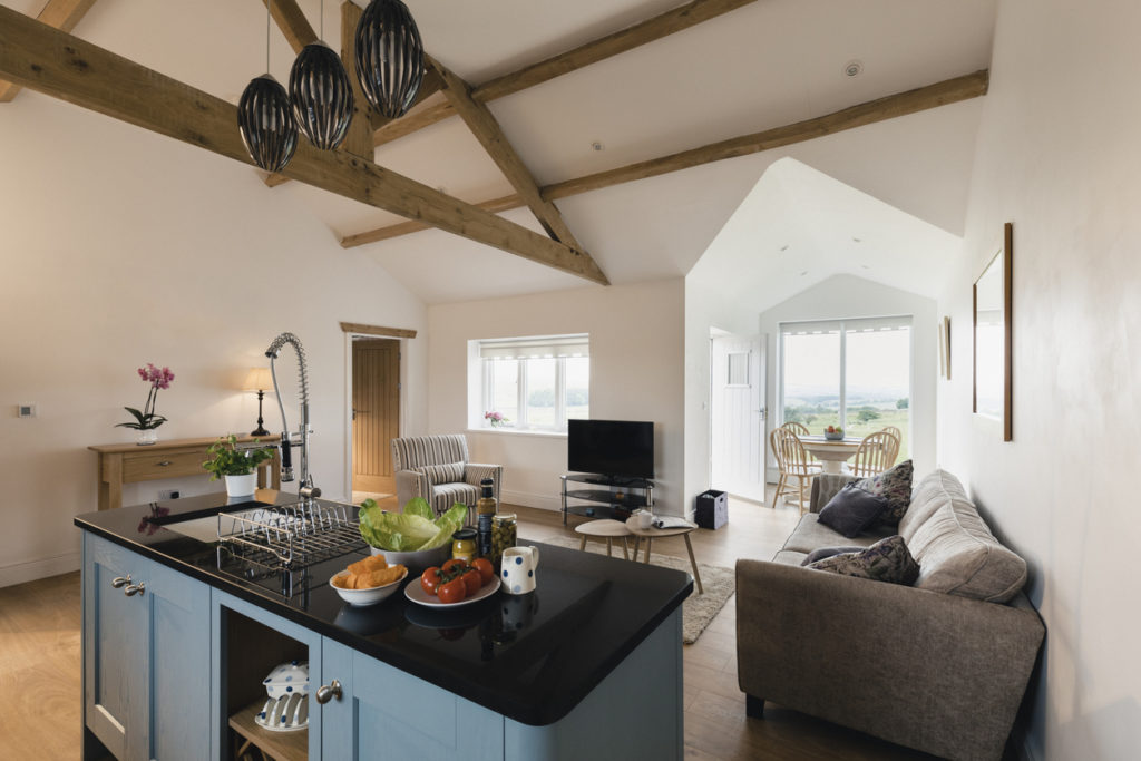 A wide-view shot of a modern living room and kitchen in Northeastern England.