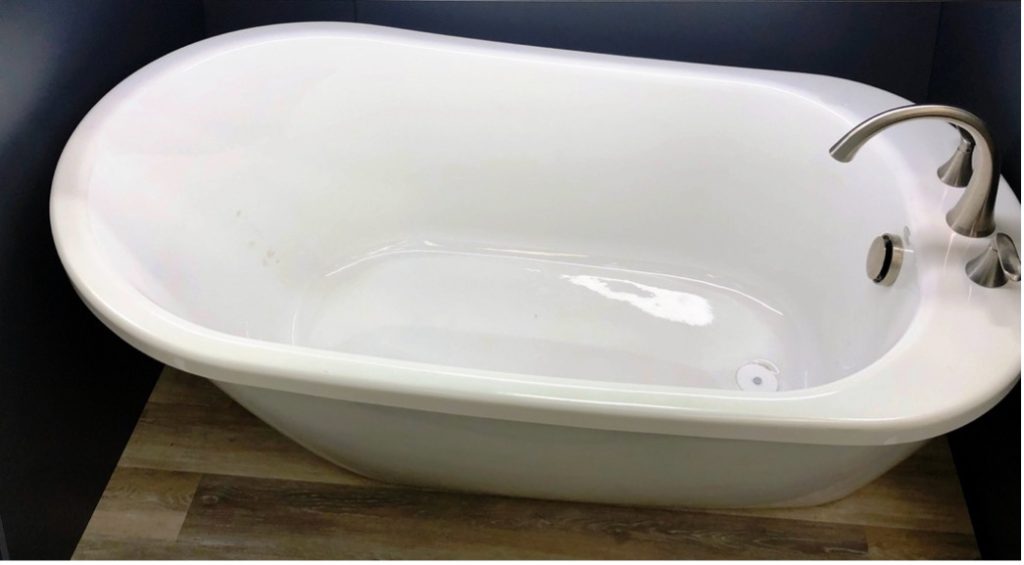 A white bathtub on a wood surface